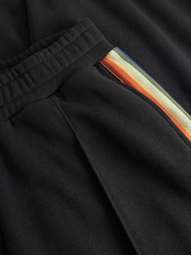 Mademoiselle YéYé Regenbogen Sweathose aus Bio-Baumwolle Rainbow Vibe Trousers Farbe/Muster: Black Entspannte Hose im Tracksuit Style. Mit der passenden Jacke = Grande Amore! Natürlich sind alle Farben im Regenbogen auch in der Kollektion zu finden. Also kombiniere die Hose mit unseren uni Tops und Shirts. Nachhaltig und zertifiziert Weiches Sweat-Material Langes, gerades Bein Abgesteppte Biese vorne Gummibund Seitliche Eingriffstaschen Leistentaschen hinten Regenbogenband auf den Seitennähten 100% Baumwolle (organic)