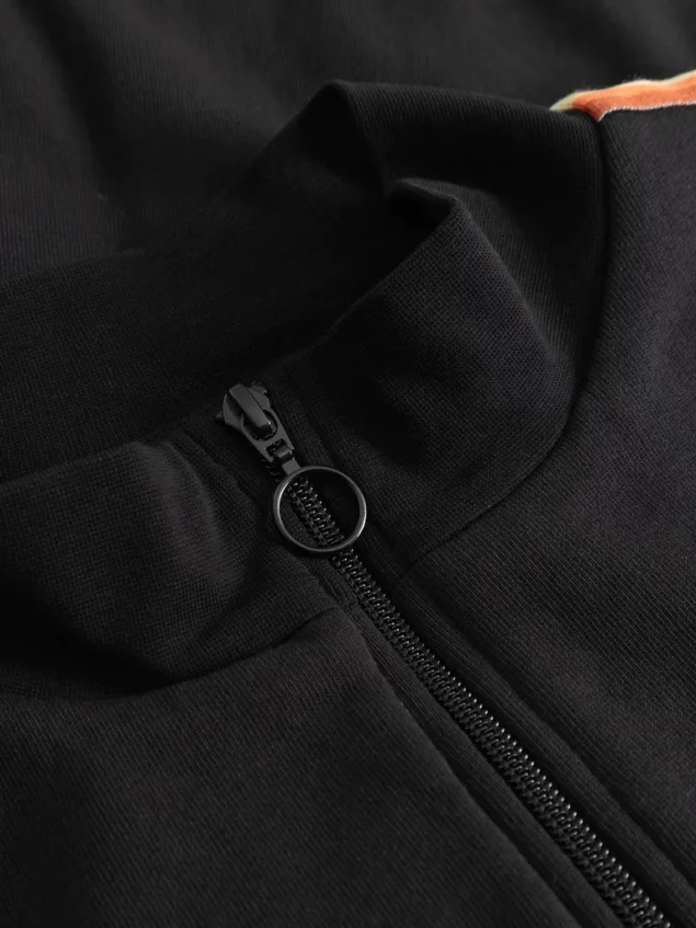 Mademoiselle YéYé-Regenbogen Sweatjacke aus Bio-Baumwolle Farbe/Muster: Black Rainbow Lover Jacket Cool, cooler – Rainbow Lover Jacket. Eine schlichte Trainingsjacke, aber mit dem gewissen Extra! Noch cooler mit der passenden Hose. Nachhaltig und zertifiziert Weiches Sweat-Material Normale Länge und Passform Reißverschluss vorne Stehkragen aus Rippmaterial Regenbogenband auf den Ärmeln Dezente Bruststickerei 100% Baumwolle (organic)