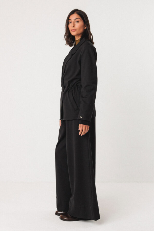 skfk-Blazer Iratz Schwarz Gerade geschnittener Blazer Verstellbare Taille mit elastischem Kordelzug innen Knopfverschluss vorne und komplett gefüttert Material: 82 % Modal Tencel™ 14 % Recycltes Nylon 4% Elasthan