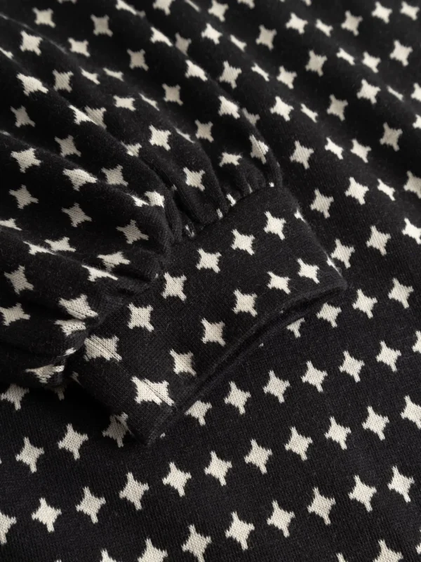Strickkleid mit Ballonärmeln aus Bio-Baumwolle Nachhaltig und GOTS zertifiziert Elastischer Jacquard-Strick Langes, ausgestelltes Bein Elastischer Gummibund Schräge Eingriffstaschen vorne Leistentaschen hinten Sitzt wie ‘ne Eins, sieht aus wie ‘ne Zehn und zaubert garantiert eine mega Silhouette! Das Kleid im 60s-Stil mit subtilem Black-&-White-Stern-Design ist ein echtes Basisteil für unsere Herbst- und Wintergarderobe. Zeitlos und wow!